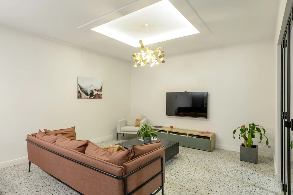16-salon-television-meuble-tv-plantes-tableau-led-luminaire-corniche-faux-plafond-canape-rose-sol-terrazzo
