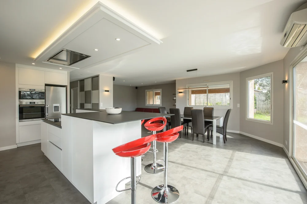 06-beaux-interieurs-tabouret-ilot-central-rouge-faux-plafond-noir-blanc-corniches-moderne