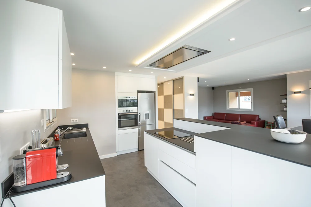 07-cuisine-agencement-équipée-belle-plan-de-travail-noir-ardoise-sans-poignée-blanc-placards-hotte-encastrée-plaque-de-cuisson-cafetière-rouge-couleur