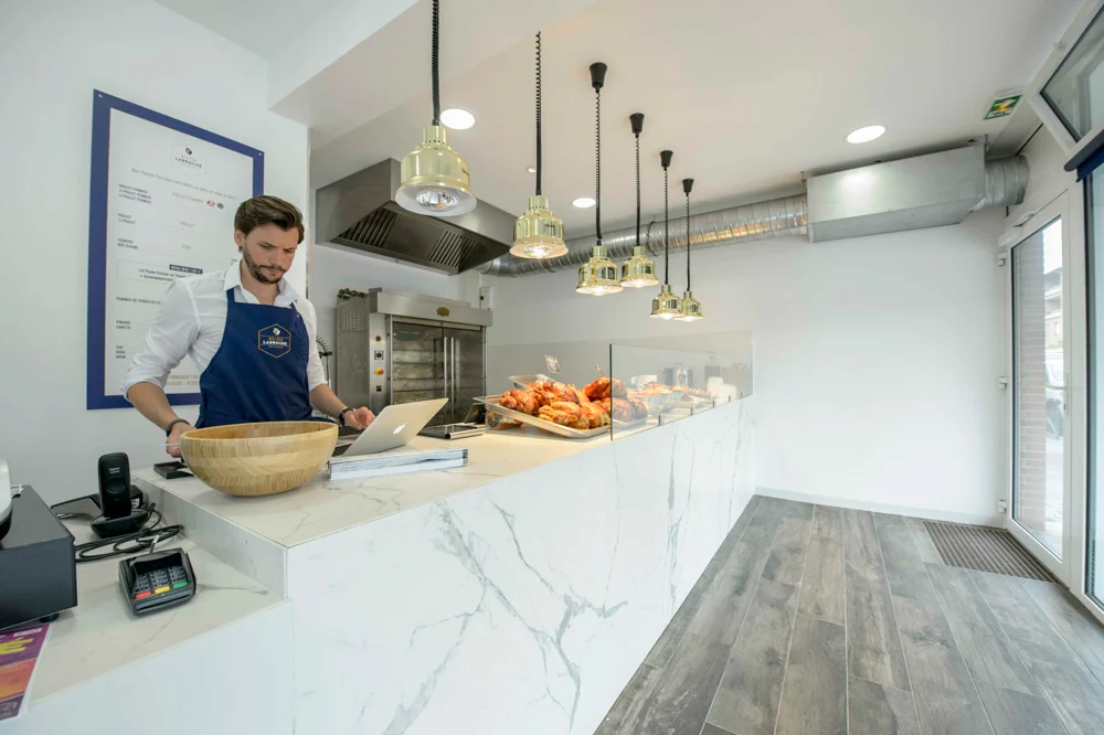 rotisserie-proprietaire-interieur-comptoir-marbre-lampe-carrelage-bois-faience-blanche-chaleur-affichage-menu